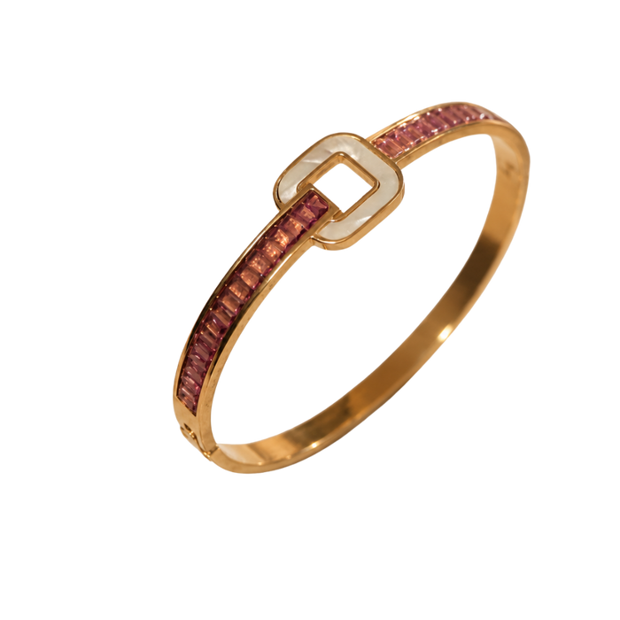A gold bangle bracelet featuring a channel-set row of pink stones on one side and a polished gold square buckle closure on the other, shown against a plain white background.