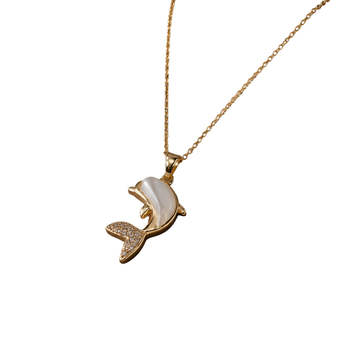 A gold-tone necklace with a dolphin pendant featuring a white mother-of-pearl shell inlay and small clear rhinestone accents on the tail, shown against a plain white background.