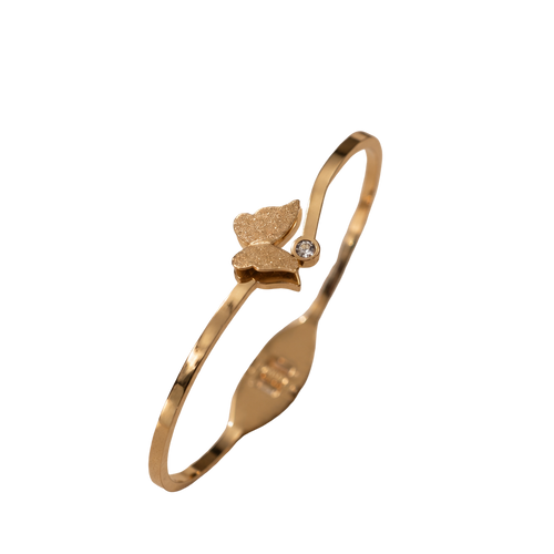 A gold-plated bangle bracelet with a small butterfly charm and a tiny clear stone, shown on a plain white background.
