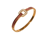 A gold bangle bracelet featuring a channel-set row of pink stones on one side and a polished gold square buckle closure on the other, shown against a plain white background.