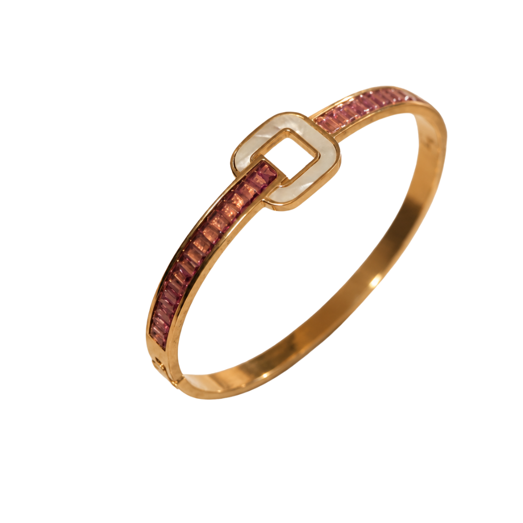 A gold bangle bracelet featuring a channel-set row of pink stones on one side and a polished gold square buckle closure on the other, shown against a plain white background.