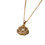A gold pendant necklace featuring a crown-like design with a central clear gemstone and small pavé-set stones, suspended from a delicate gold chain against a plain white background.