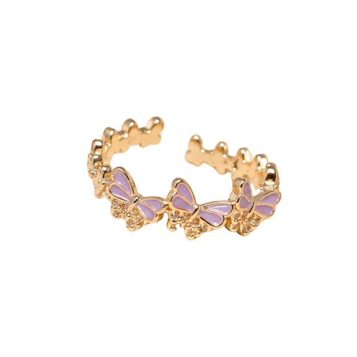A gold-plated open ring band decorated with a row of small butterfly charms featuring light purple enamel wings, set against a plain white background.