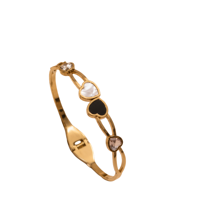 A gold-plated bangle bracelet featuring three heart-shaped inlays in white, black, and brown, with small clear stones at the ends, shown on a plain white background.