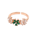 A rose gold adjustable ring featuring a central green four-petal flower motif flanked by small clear crystal clusters, shown on a plain white background.