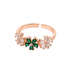 A rose gold adjustable ring featuring a central green four-petal flower motif flanked by small clear crystal clusters, shown on a plain white background.