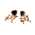 A pair of rose gold earrings featuring a polished triangular black stone inlay, set within an organic, branch-like rose gold metal design, shown against a plain white background.