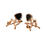 A pair of rose gold earrings featuring a polished triangular black stone inlay, set within an organic, branch-like rose gold metal design, shown against a plain white background.