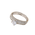 A silver-toned diamond ring with a single round-cut center stone and pavé-set side stones, shown on a plain white background.