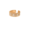 A gold-plated adjustable ring with a white enamel center and embossed starburst details, shown on a plain white background.